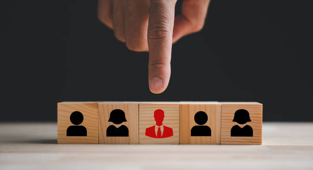istock Hand reaching for red human icon on wooden block 1807261819