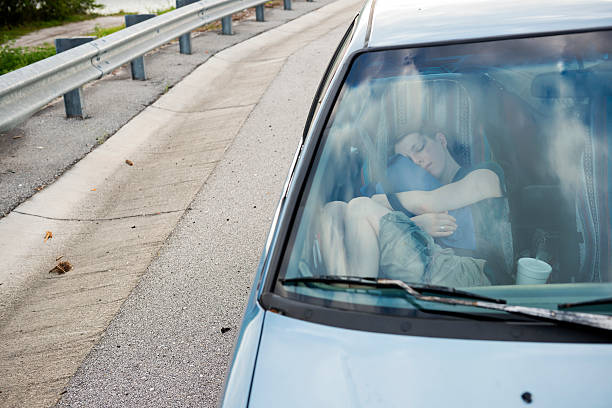 Tired driver sleeps in the cab of his truck and hugs his child's toy. View inside of vehicle cabin.