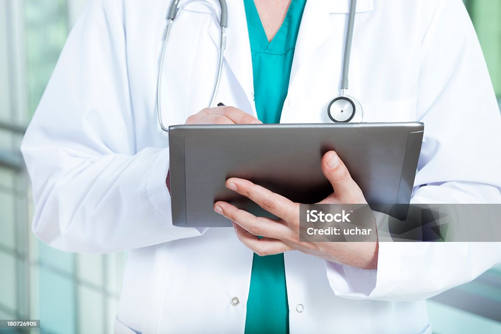 Torso view of a doctor consulting a tablet computer Digital Doctor Electronics Industry Stock Photo