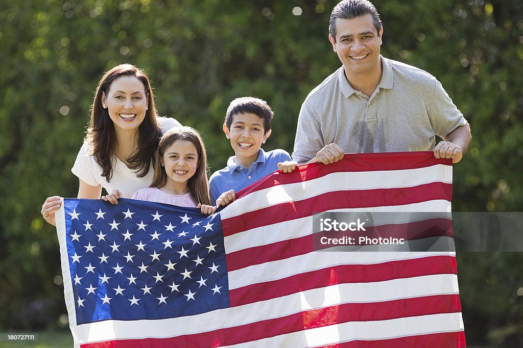 Famille tenant le drapeau américain sur le parc - Photo de 4 juillet libre de droits