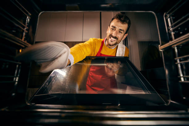 istock View from the oven of a happy man baking dinner at home. 1807290147