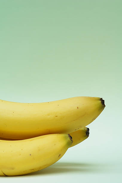 istock Ripe Bananas on Mint Green Background 180729807