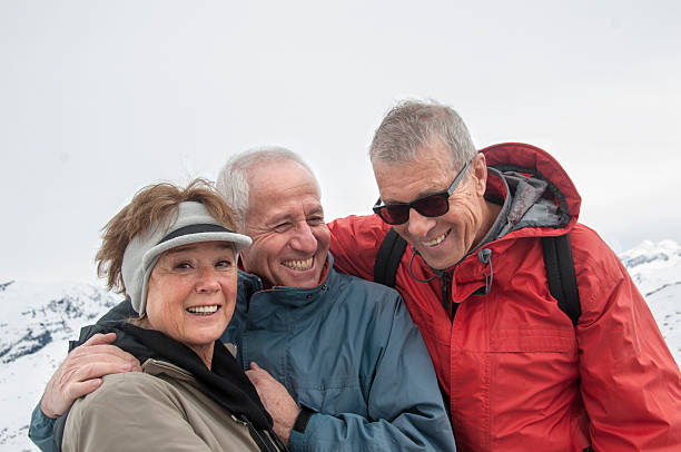 tres jubilados feliz divirtiéndose durante el invierno deportes 2 - apres ski friendship skiing enjoyment fotografías e imágenes de stock