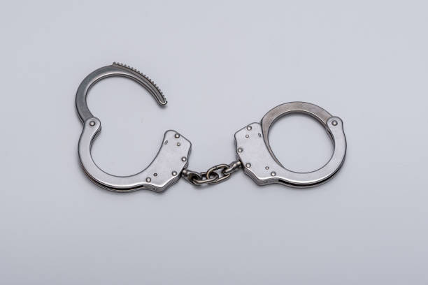 istock Steel handcuffs isolated on light background close up 1807310312