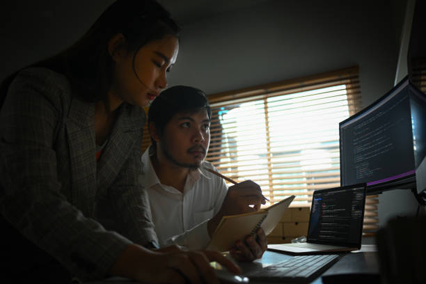 istock Team of young professionals brainstorming and working in software development in dark office 1807317261