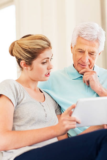 istock Granddaughter With Senior Man Using Digital Tablet 180731773