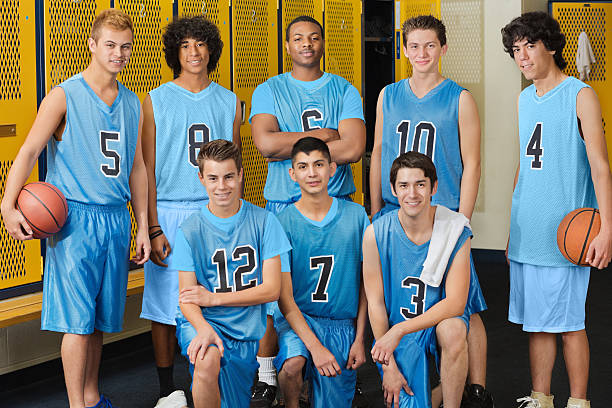 High school basketball team posing in locker room High school basketball team posing in locker room jersey fabric photos stock pictures, royalty-free photos & images