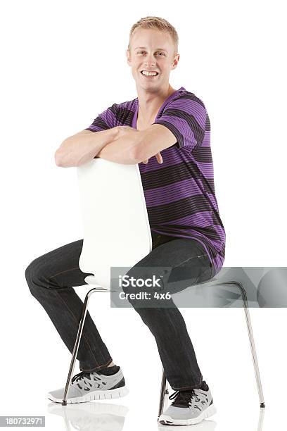Foto de Homem Sentado Em Uma Cadeira À Frente e mais fotos de stock de Cadeira - Cadeira, Detrás para Frente, Pessoas