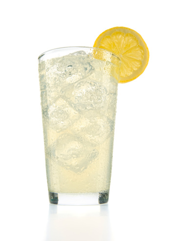 Big glass of ice cold lemonade with a lemon wheel.
