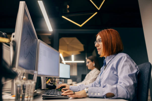 istock Side view of an architect working on blueprints and project at office on a computer. 1807334767