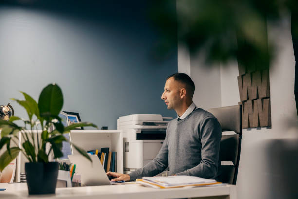 istock Side view of an executive sitting in corporate company and using technologies for work. 1807335819