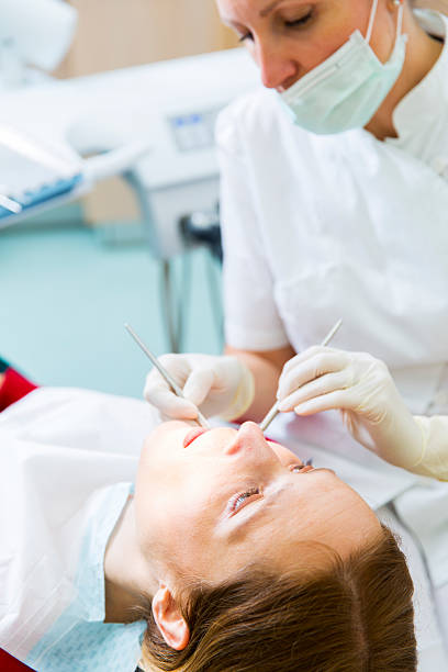 istock Female dentist at work with her patient 180733686