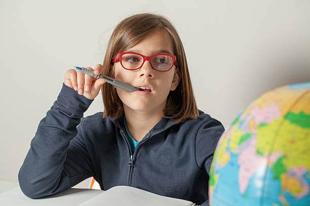 Little Girl Thoughtful While Doing Her Homework stock photo