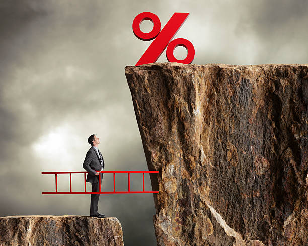 Businessman holding ladder staring up at higher interest rates A businessman with a ladder looking up at higher interest rates. rising interest rate stock pictures, royalty-free photos & images