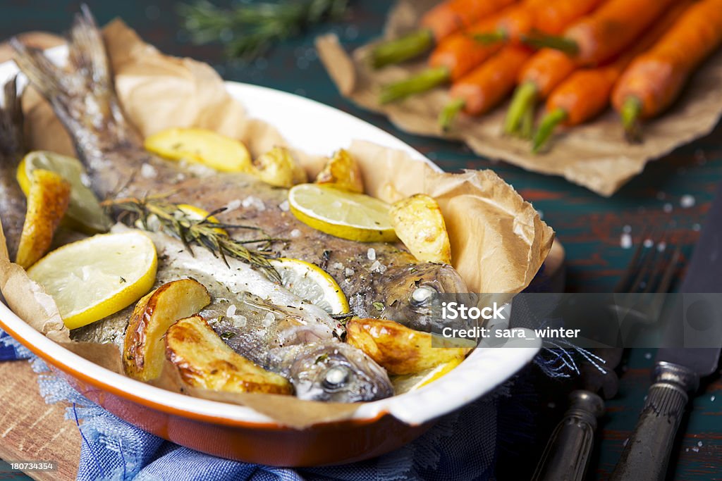 Ofen Gebratene Forelle und Gemüse auf rustikalen Tisch - Lizenzfrei Auflauf Stock-Foto