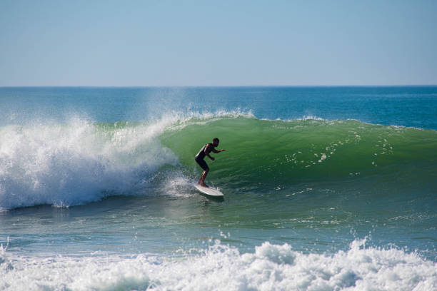 Surfer in action in the tubular waves of the Atlantic Ocean Image of a surfer in a wave lit by backlight bayonne stock pictures, royalty-free photos & images