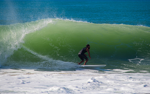 Image of a surfer in a wave lit by backlight