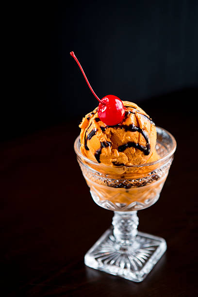istock Orange ice cream sundae with chocolate syrup and cherry 180734880