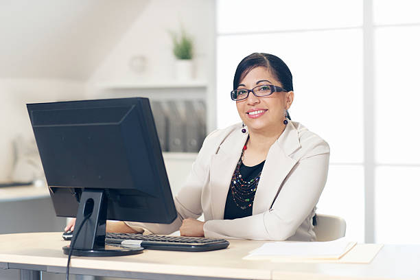 istock Hispanic Woman Sitting in Front of Computer at Office 180735684