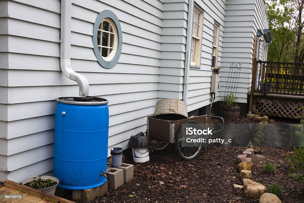 Rain Barrel "Rain barrel, also known as water butt, used to collect rainwater to use for watering gardens, washing cars, etc." Rainwater Tank Stock Photo