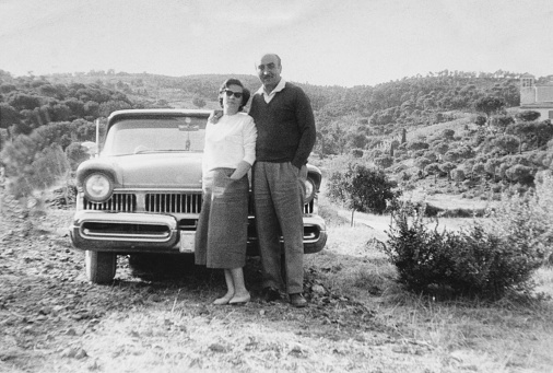 Young couple and vintage car in a country road. 1952.