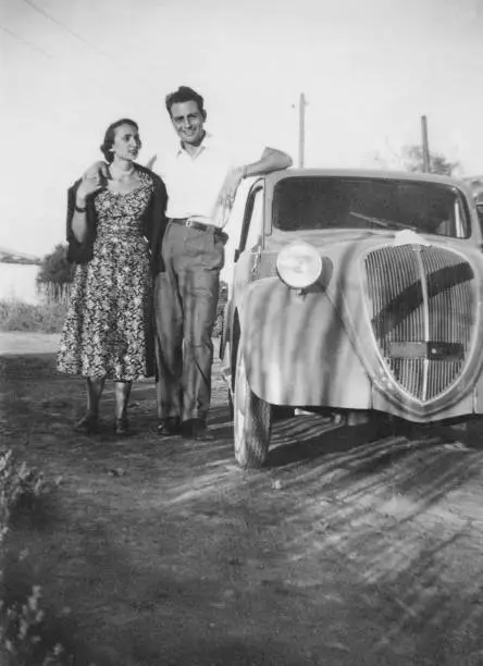 Young couple and vintage car in a country road. 1952.