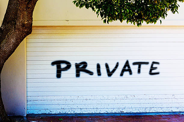 Decorative gate with private property sign and golden spikes in blurred outdoor setting
