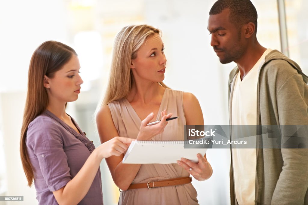 What do you think of this proposal? Three colleagues discussing a memo at work Adult Stock Photo