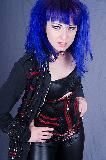 istock Blue haired woman in punk goth outfit leaning forward. 180738976