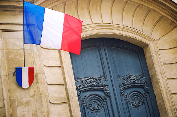istock French Flag Flies Above Plaque on Paris Building 180739311