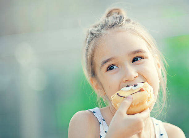 istock A blonde girl eating a doughnut 180741456