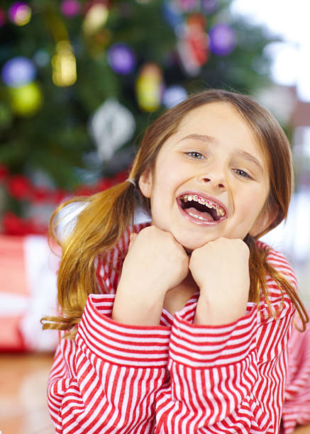 Kid girl in Santa hat poses and fun at Christmas time. Merry Xmas background.
