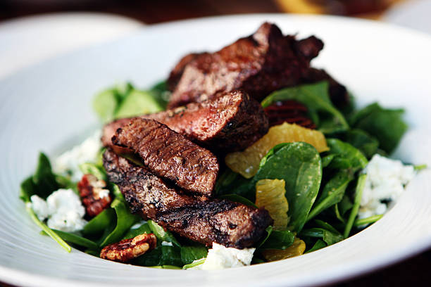 Dinner consisting of steak and a spinach salad