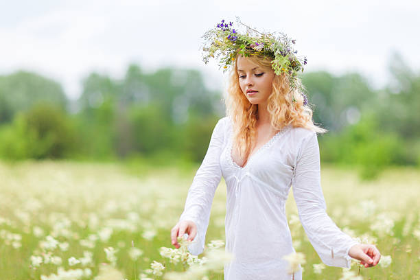 Woman on green field with wreath of flowers on her head.