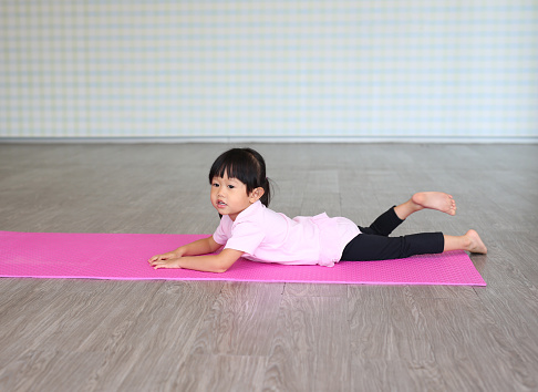 Little girl practicing yoga or exercise