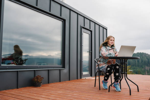 istock Woman remote work on laptop while sitting at a table outdoors. Girl working with a great view mountains. Workplace in country in backyard house in morning. Concept freelance lifestyle. Internet 5G. 1807427909