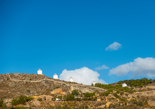Panteli village is a traditional Greek village with white buildings and windmills on top of a hill