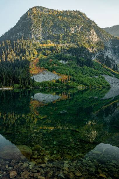 istock Vertical of a green mountain reflecting on a lake 1807436548