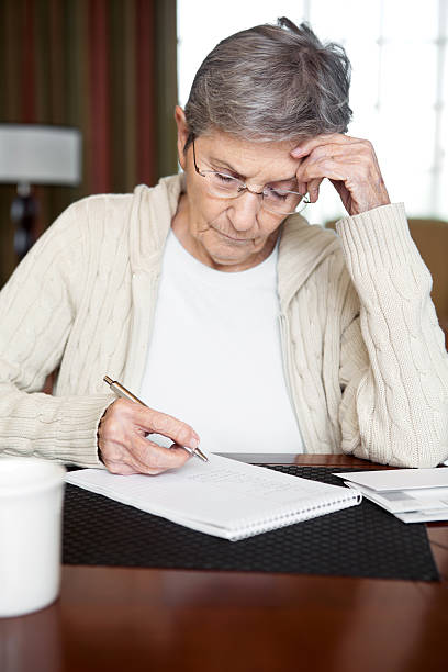 istock Senior Woman budgeting and paying bills 180744230
