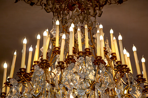 Electric candles on a chandelier with tassels