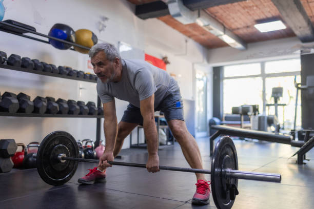 istock An elderly man is working out in the gym, lifting weights 1807447281