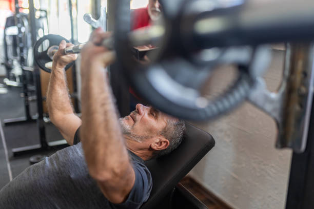 istock An elderly instructor assists an elderly man to exercise in the gym 1807453182