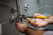 Handyman repairing bathroom pipes