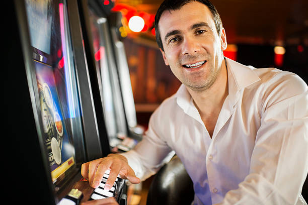 istock Man gambling on slot machines. 180745331