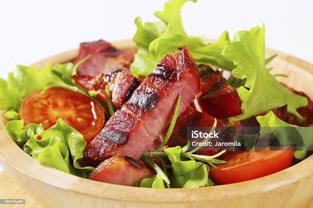 Tiras de bacon grelhado com salada de legumes em um prato - Foto de stock de Alface royalty-free