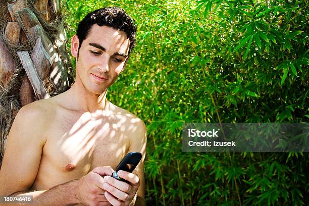 Rilassata Giovane Uomo Con Il Cellulare - Fotografie stock e altre immagini di A petto nudo - A petto nudo, Abbigliamento casual, Abbronzatura