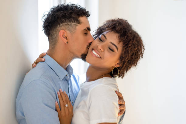 istock Man kissing his girlfriend at home 1807469535