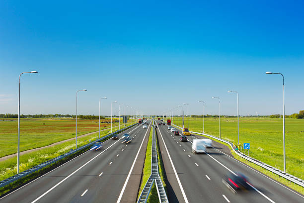 istock Highway through grassy fields on a sunny day, The Netherlands 180747558