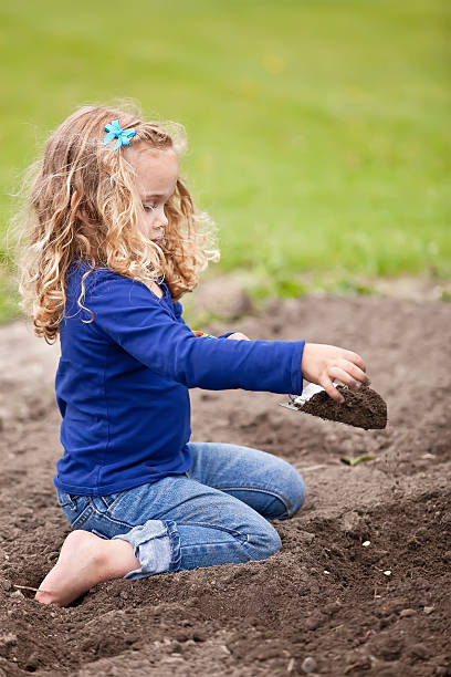 istock Girl Planting Pumpkin Seeds 180747956