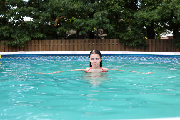 Young woman in backyard above ground pool